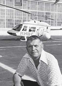 Francis Powers kneeling in front of a helicopter.