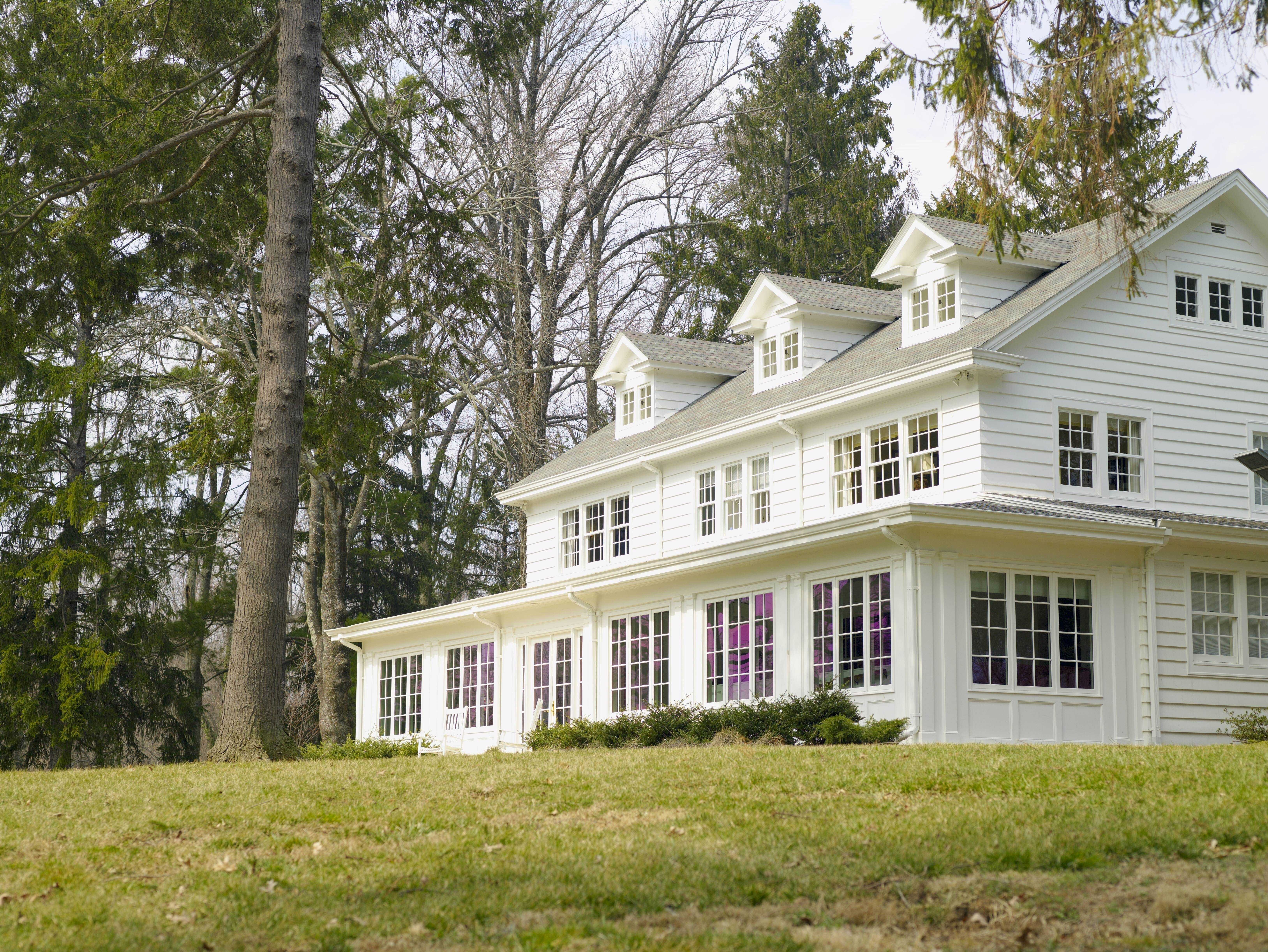 An isometric view of the white manor with rows of windows.